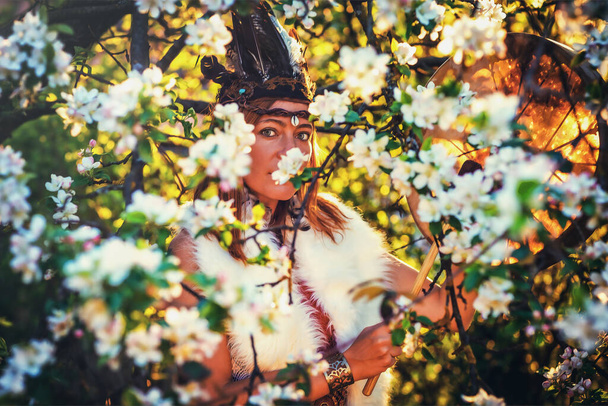 gyönyörű sámáni lány játszik a sámán keret dob a természetben és a fény grafikus hatása - Fotó, kép