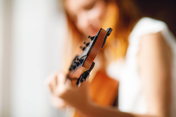 woman playing with guitar and blurred background - Photo, image