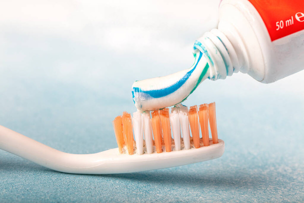 Cepillo de dientes con pasta de dientes sobre fondo de madera azul
. - Foto, Imagen