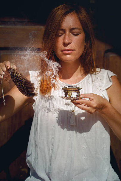 Weihrauch in einer Frauenhand, Räucherrauch auf verschwommenem Hintergrund - Foto, Bild