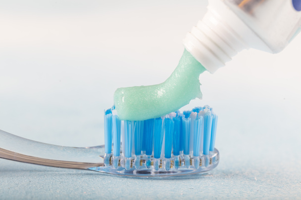 cepillo de dientes en la mesa con pasta de dientes y tubo de pasta de dientes sobre fondo borroso
 - Foto, Imagen