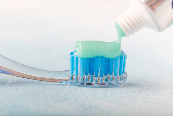 зубная щетка на столе с зубной пастой и тюбиком зубной пасты на размытом фоне
 - Фото, изображение