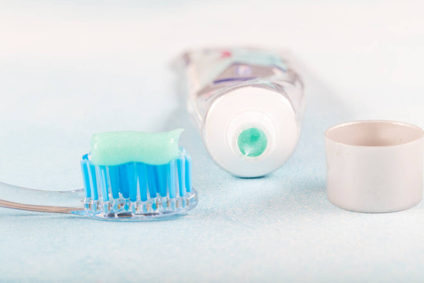 toothbrush on the table with toothpaste and toothpaste tube on blurred background - Photo, Image