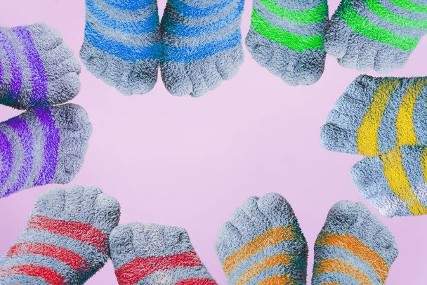 six paires de jambes en chaussettes rayées avec des orteils aux couleurs du drapeau LGBT forment le cadre sur fond rose - Photo, image