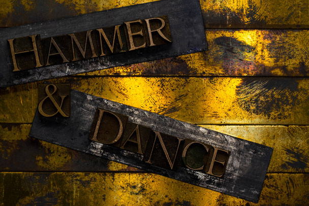 Hammer and Dance Text, geformt mit echten, authentischen Schriftbuchstaben auf silbernem Grunge Kupfer und Gold Hintergrund - Foto, Bild