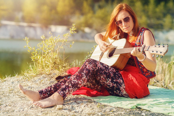 beautiful woman playing with guitar in nature. - Photo, Image