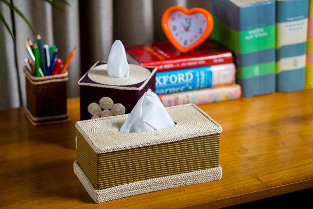A tissue box on a wooden reading table. A tissue box made of fiber. Pineapple leaf fiber. - Photo, Image