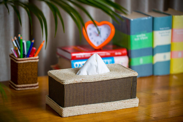 Una caja de pañuelos en una mesa de madera. Una caja de tejido hecha de fibra. Fibra de hoja de piña
. - Foto, Imagen