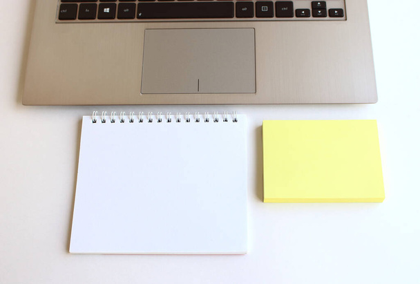 Moderne werkruimte met notebook, tablet en laptop kopieerruimte op witte achtergrond. Bovenaanzicht. Platte lay stijl. - Foto, afbeelding