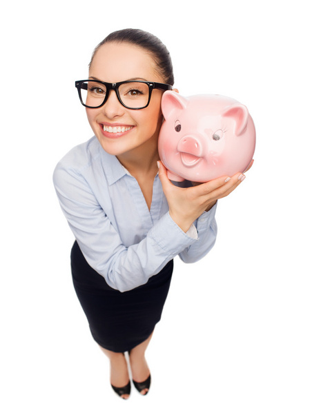 Happy businesswoman in eyeglasses with piggy bank - Fotografie, Obrázek