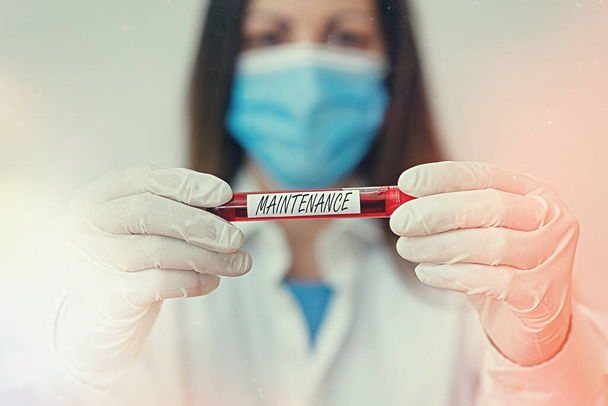 Writing note showing Maintenance. Business photo showcasing method of preserving or maintaining someone or something Laboratory blood test sample for medical diagnostic analysis. - Photo, Image