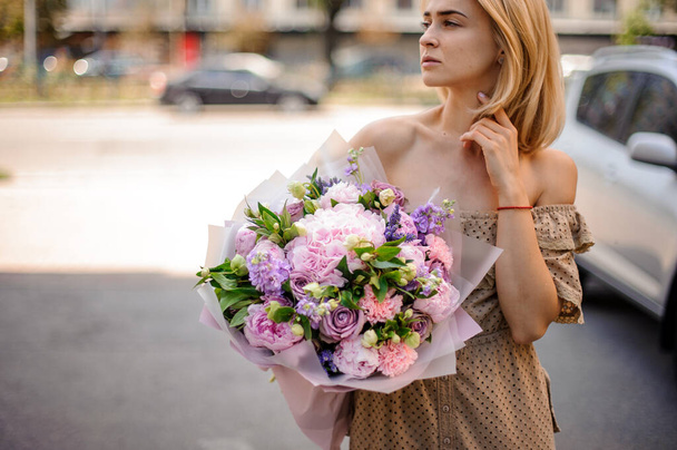 young attractive woman holds tender bouquet of flowers - Foto, Imagem