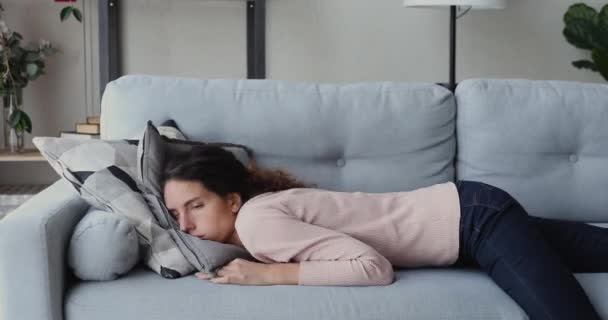 Unhappy young woman falling down on comfort couch, feeling exhausted. - Video