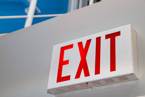 Une vue en perspective depuis un angle bas montrant un panneau rouge "EXIT" sur un mur blanc. - Photo, image