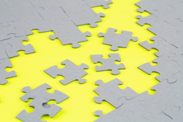 Unvollendete Puzzleteile auf gelbem Hintergrund. - Foto, Bild