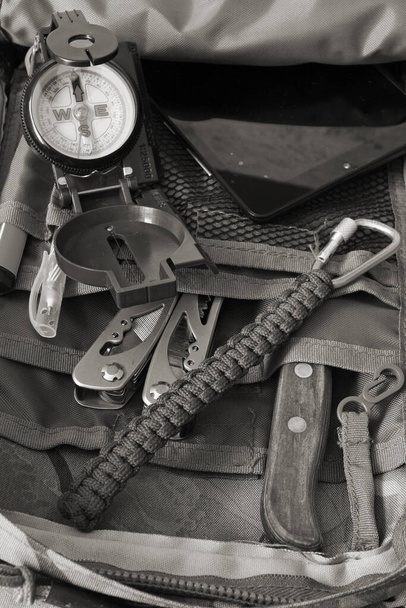 Compass, knife and multitool in a backpack - Foto, imagen