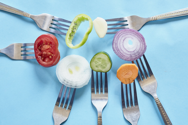 Trozos de verduras frescas en rodajas en los tenedores
 - Foto, imagen