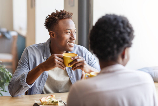 czarny facet i dziewczyna na pierwszej randce w nowoczesny kawiarnia - Zdjęcie, obraz