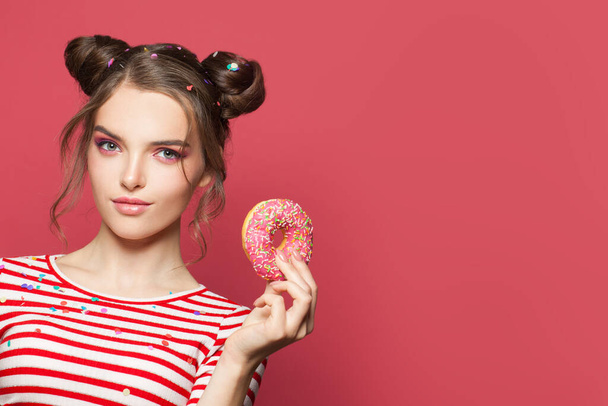 Menina bonito com donut em rosa
 - Foto, Imagem