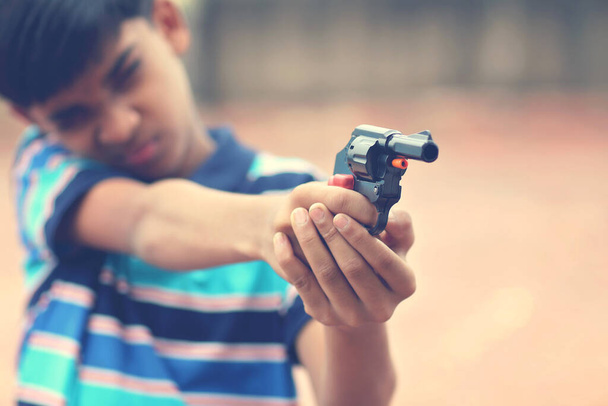 Портрет індійського хлопчика з іграшковим пістолетом. - Фото, зображення