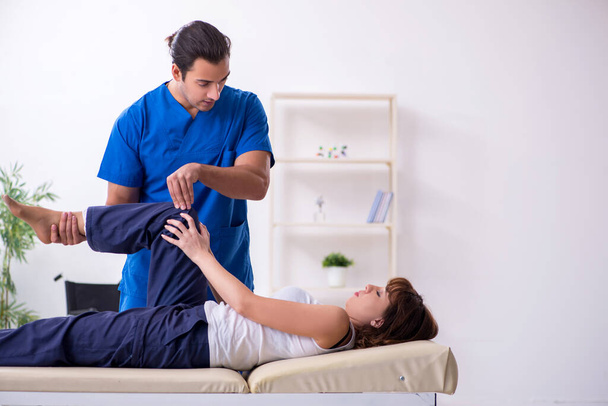 Yaralı kadın genç erkek doktor osteopat 'ı ziyaret ediyor. - Fotoğraf, Görsel