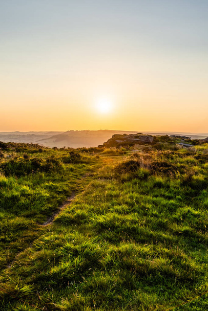 Following the path along Curbar Edge on a clear evening with a beautiful sunset. - Foto, afbeelding