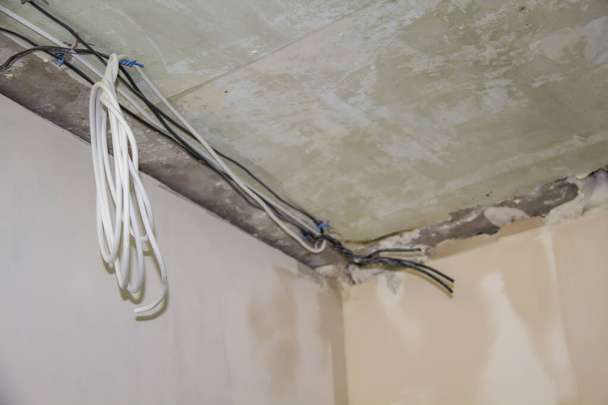 Reparaturarbeiten in der Wohnung. Konzept der Heimwerker oder renovieren. Grundierte Malwände und Kabel für Elektrizität - Foto, Bild