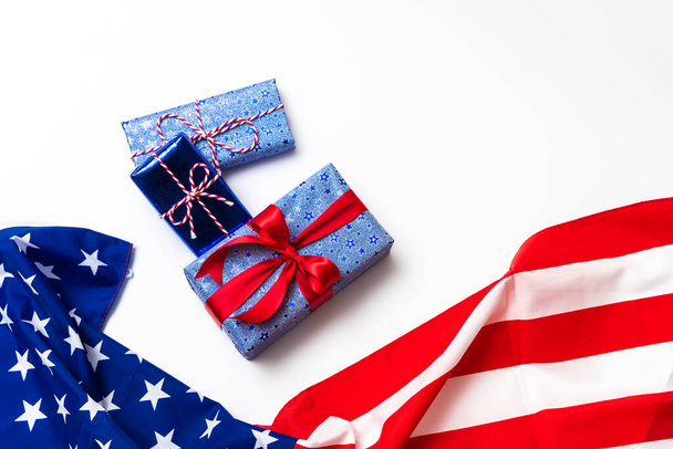 4. Juli American Happy Independence Day Karte mit Geschenkschachteln in den Nationalfarben Amerikanische Flagge auf weißem Hintergrund, Flache Lage, Draufsicht, Kopierraum, Banner - Foto, Bild