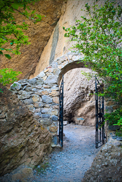 Arch with the forged gates on a mountain path - Fotó, kép