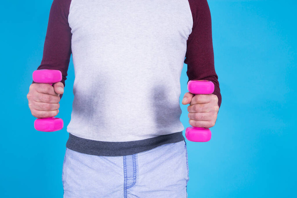 man doing dumbbells with blue background - Foto, immagini