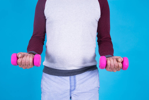 man doing dumbbells with blue background - Foto, immagini