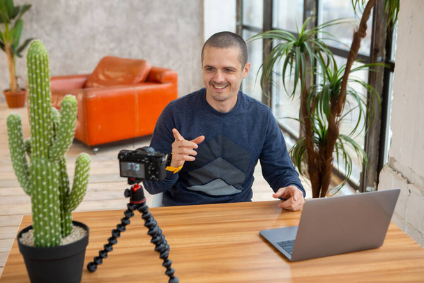 Uomo blogger con fotocamera e laptop riprese video per blog. - Foto, immagini