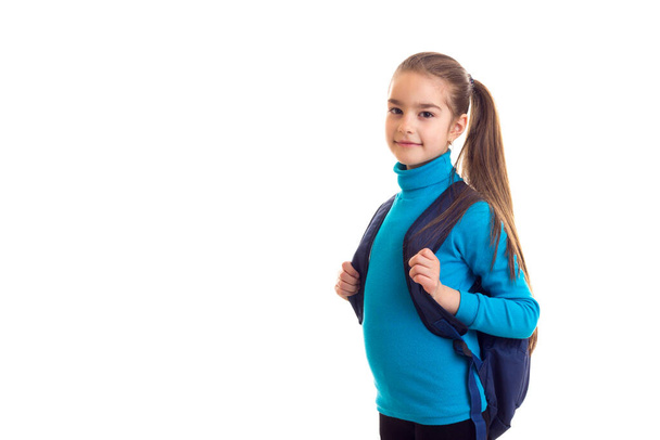 Милая школьница с сумкой на спине, смотрит в камеру
 - Фото, изображение