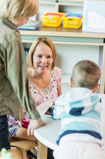 Cheerful Teacher With Children In Library - Fotografie, Obrázek