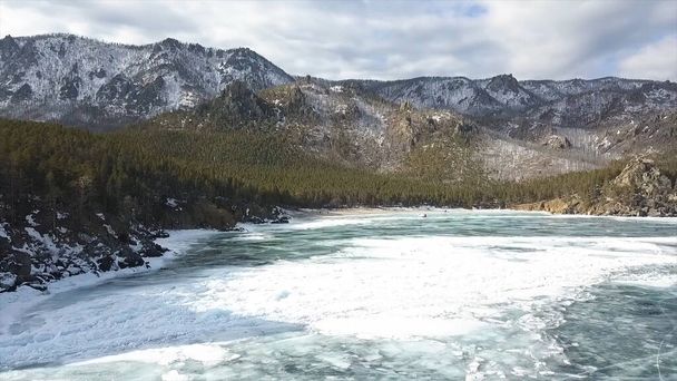 Вид с воздуха на захватывающий природный фон с замерзшим озером и горами. Клип. Лесные холмы и голубая ледяная поверхность гигантского водохранилища
. - Фото, изображение