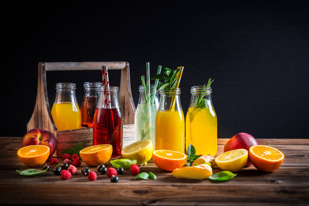 Asortyment soków i lemoniad z owocami i ziołami na drewnianym stole - Zdjęcie, obraz