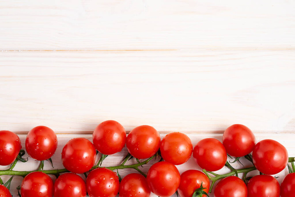 Cherry tomatoes on the white wooden table. Juicy ripe vegetables. Healthy eating. vegetarian food - Fotografie, Obrázek