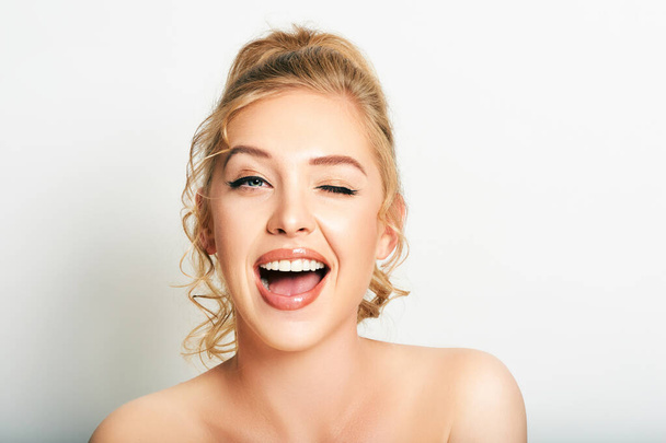 Portrait of beautiful excited young woman winking eye and smiling - Photo, Image