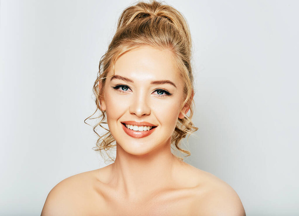 Közelkép portré gyönyörű fiatal nő fehér háttér, vidám lány boldog mosollyal és tökéletes puha bőr - Fotó, kép