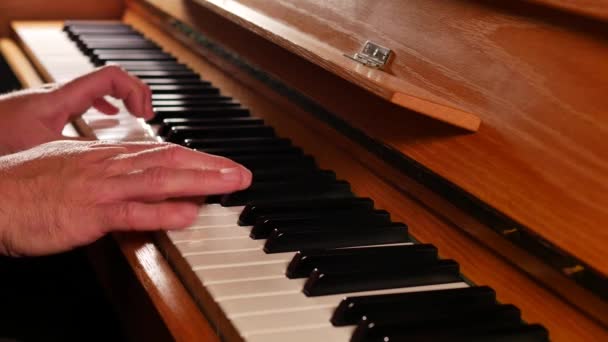close-up beelden van de man die piano speelt met achtergrondverlichting - Video
