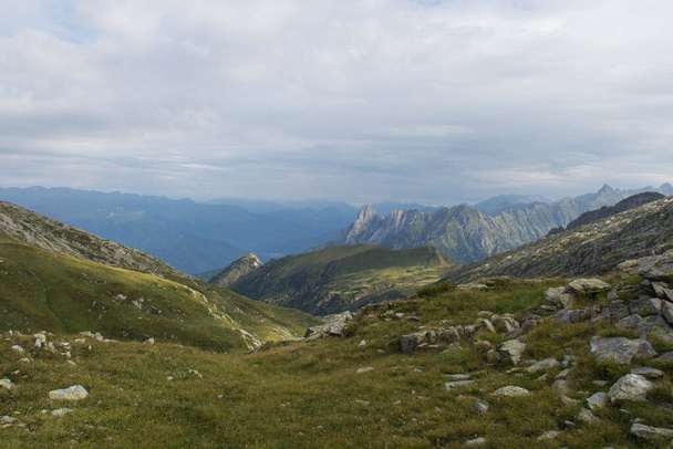 Вид на склон с зеленой травой и горами на фоне, Долина Браоне, Италия
. - Фото, изображение