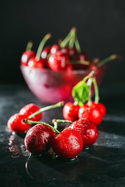 Fresh, wet red cherries on dark background, close-up view. - Fotografie, Obrázek