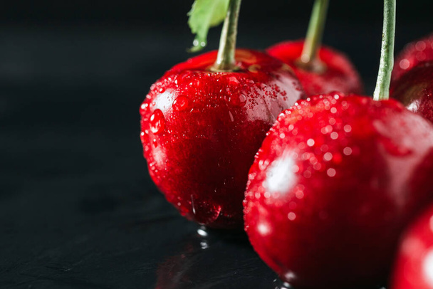 Fresh red cherries with water drops on dark background, close-up view. - Fotoğraf, Görsel