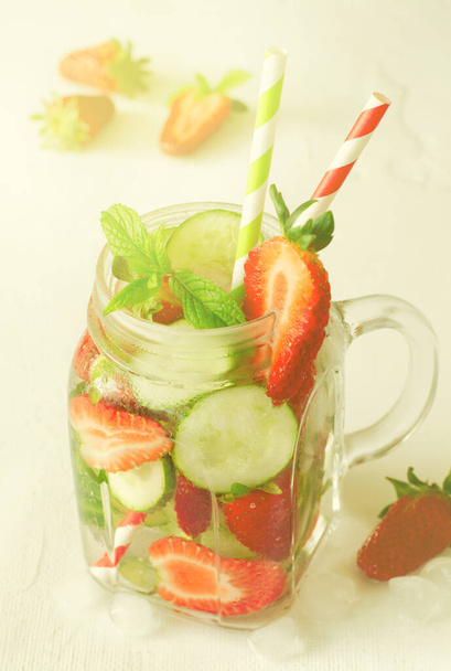 Summer refreshing iced drinks with cucumber and strawberry on white background - Фото, изображение
