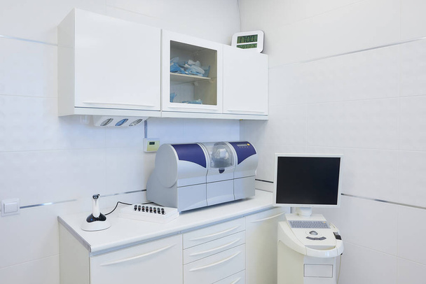 A modern interior of a dental office with a wet milling and grinding machine, an intraoral scanner, a led polymerization light. Dentist's office. Dental laboratory - Фото, изображение