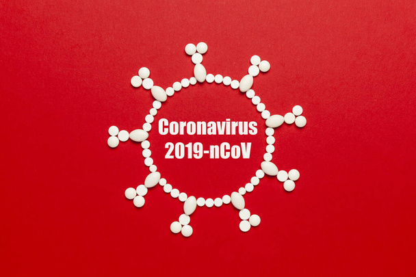 Kırmızı arka plandaki haplardan oluşan virüs konsepti. Koronavirüs salgını (2019-nCoV), tehlikeli zatürree ve karantina. - Fotoğraf, Görsel