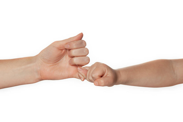 Anne ve çocuğun elleri küçük parmaklarıyla birbirlerini tutarlar, barış ya da yemin. Parmak izi anlaşması beyaz arkaplanda izole edildi. - Fotoğraf, Görsel