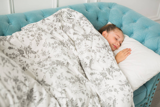 beautiful young teenager girl in a blanket lies on a pillow - Φωτογραφία, εικόνα