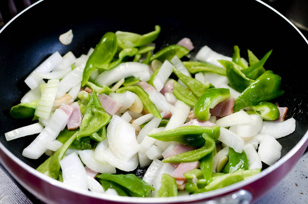 перемішати смажені овочі та беконну ковбасу на сковороді
 - Фото, зображення