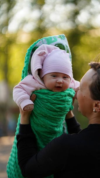 O pai tem uma filha recém-nascida nos braços. Bebê em romper verde rindo alegremente
 - Foto, Imagem